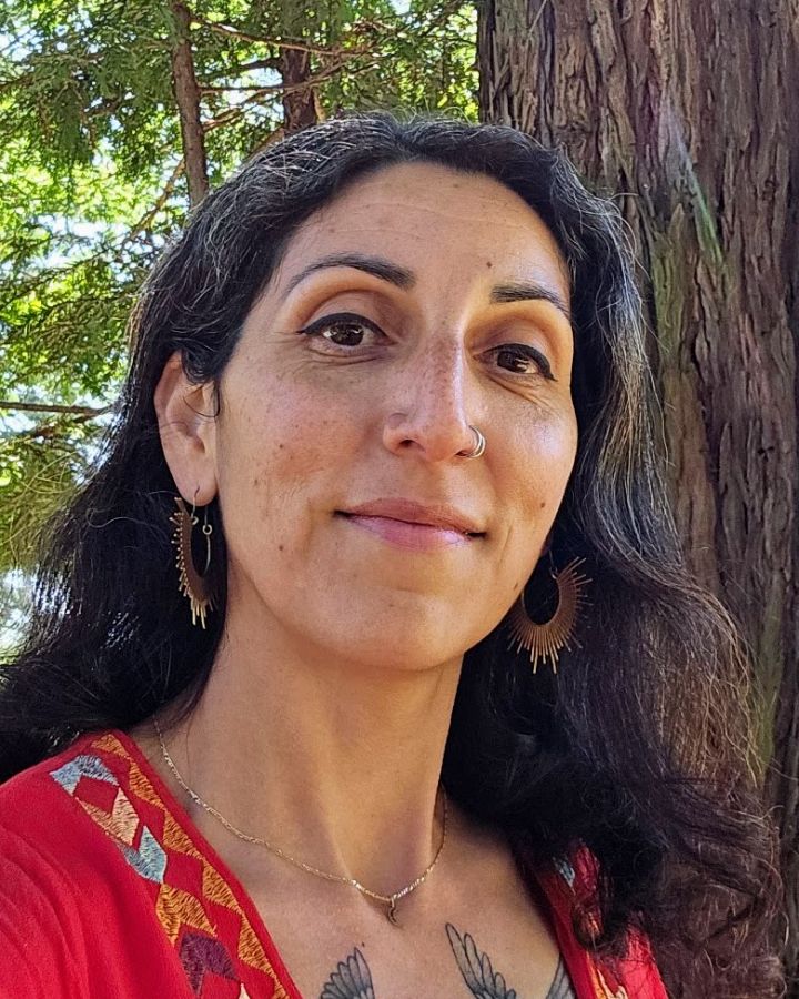 Jasmin Tokatlian smiling outdoors among redwood trees.